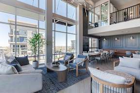 a living room with couches and a table with chairs and a balcony