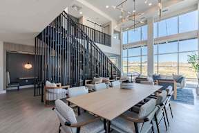 a dining room with a large table and chairs and a wall of windows