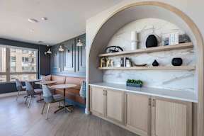 a dining room with tables and chairs and a counter with shelves