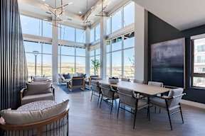 a dining room with a table and chairs and large windows