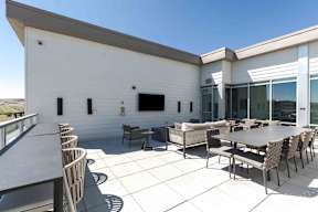 a large patio with tables and chairs and a wall mounted tv