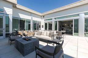 a covered patio with furniture and a fire pit