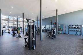 a gym with cardio equipment and weights in a building with blue walls