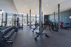 a gym with cardio equipment and windows in a building