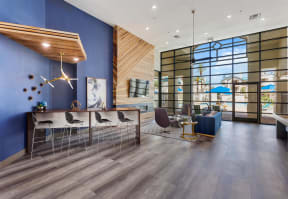A clubhouse with a blue wall and a large window with a desk and chairs in front of