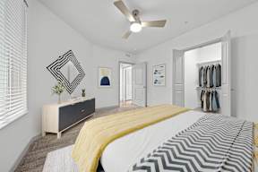A bedroom with a bed, dresser, and mirror.
