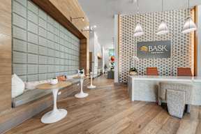 A modern cafe with wooden floors and white furniture.