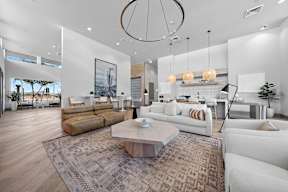 A modern living room with a white sofa set and a wooden coffee table.