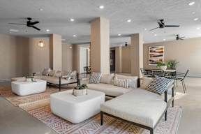A living room with a white sofa, a white coffee table, and a rug with a geometric pattern.