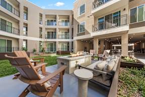 A patio area with a table, chairs and a grill.