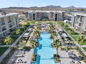 An aerial view of a courtyard pool with lounge chairs and palm trees at Bask Deer Valley apartment in complex in Phoenix, AZ.