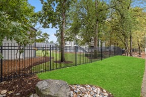 Fenced yard with mature trees and green lawn at Brookside112 Apartments, Vancouver, 98682