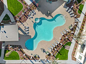 an aerial view of a swimming pool at a resort with umbrellas