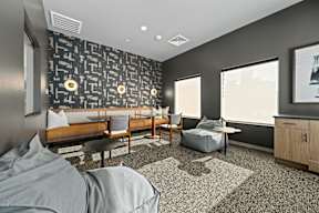 a lounge area with couches and chairs and a wall with a mural of skulls