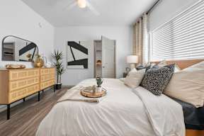 a bedroom with a large bed with white sheets and pillows