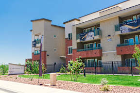 an apartment building with a yard and a sign in front of it