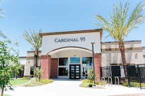the front of the cardinal 95 building with palm trees