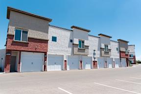 a row of townhomes in front of a parking lot