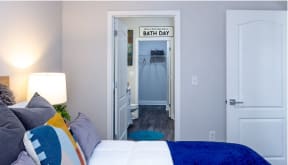 a bedroom with a bed and a hallway with a bathroom
