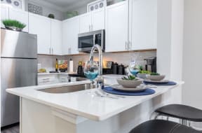 a kitchen with white cabinets and a sink and a counter top