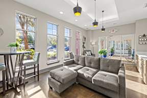 A living room with a grey sofa and a table with chairs.