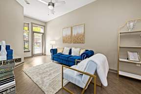 A living room with a blue couch and a white chair.