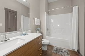 A bathroom with a white shower curtain and a white toilet.