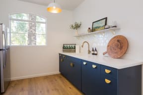 a kitchen with white walls and blue cabinets