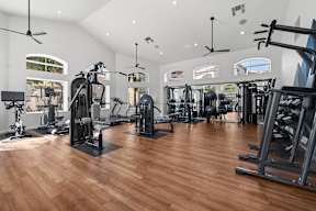 A gym with a variety of equipment including treadmills, weights, and exercise machines.