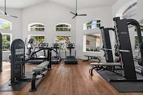 A gym with a variety of equipment including treadmills, weights, and exercise machines.