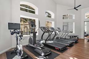 A gym with treadmills, elliptical machines, and a stationary bike.