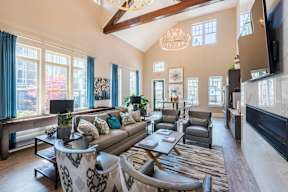A living room with a couch, chairs, and a television.