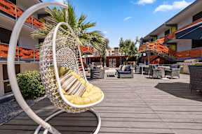 Swinging basket chair on patio deck at Crosstown Phoenix apartments for rent in Midtown Phoenix, AZ.