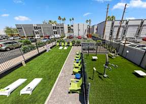 Aerial view of at courtyard lawn with cornholegames at Crosstown Phoenix apartments for rent in Midtown Phoenix, AZ.