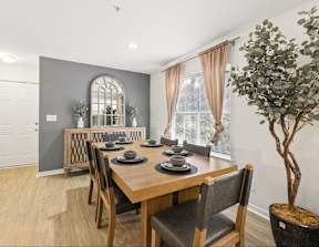 A dining room with a wooden table and chairs.