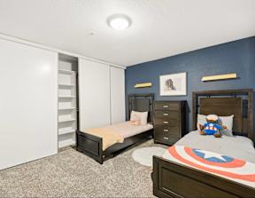 A bedroom with two beds and a dresser.