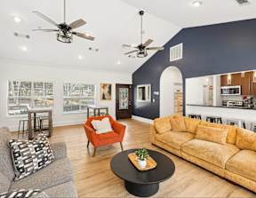 A living room with a grey couch, a red chair, and a black coffee table.