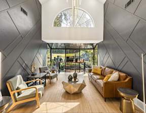 A modern living room with a large window and a wooden floor.