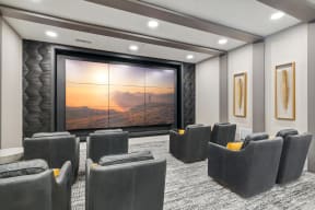 a large screening room with a projector screen and chairs