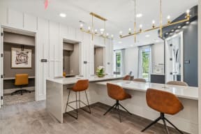 a kitchen with a long counter top and chairs