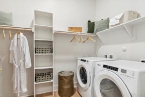 a laundry room with a washer and dryer and a closet with shelves