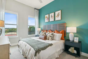 a bedroom with a large bed and two windows