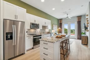 a large kitchen with stainless steel appliances and a marble counter top