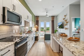 an open kitchen with granite counter tops and a marble counter top