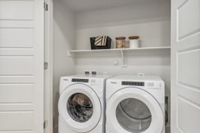a washer and dryer in a laundry room with white walls and white doors