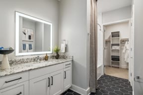 a bathroom with a large mirror and white cabinets