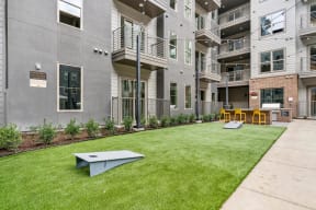 a yard with a ping pong table in front of an apartment building