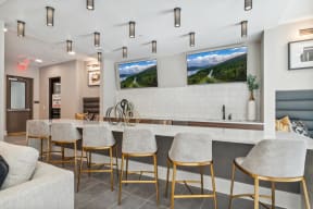 a kitchen with bar stools in front of a counter with chairs