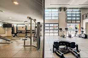 A gym with a variety of equipment including weights and exercise machines.