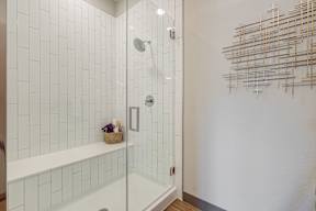Bathroom with glass enclosed shower and shower ench at Novus, Colorado